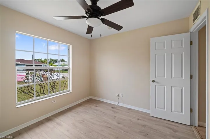 Unfurnished room featuring light hardwood / wood-style flooring, ceiling fan, and a wealth of natural light