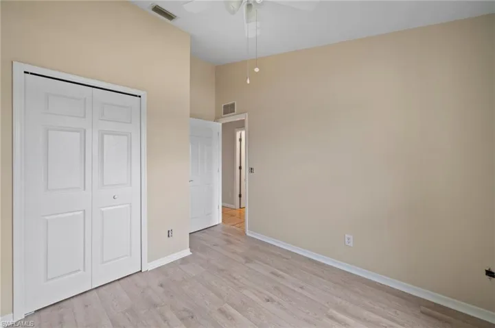 Unfurnished bedroom with a towering ceiling, light wood-type flooring, a closet, and ceiling fan