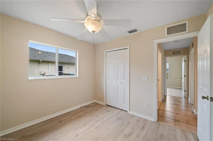Unfurnished bedroom featuring light hardwood / wood-style flooring, a closet, and ceiling fan