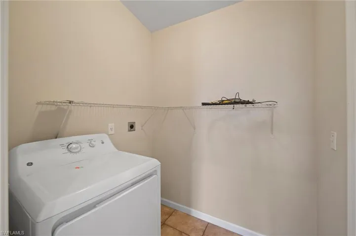 Washroom featuring washer / dryer and light tile patterned floors