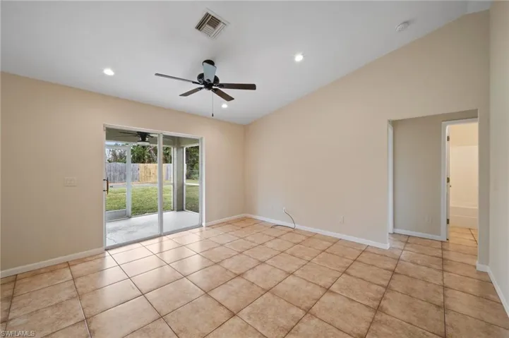 Tiled spare room featuring high vaulted ceiling and ceiling fan
