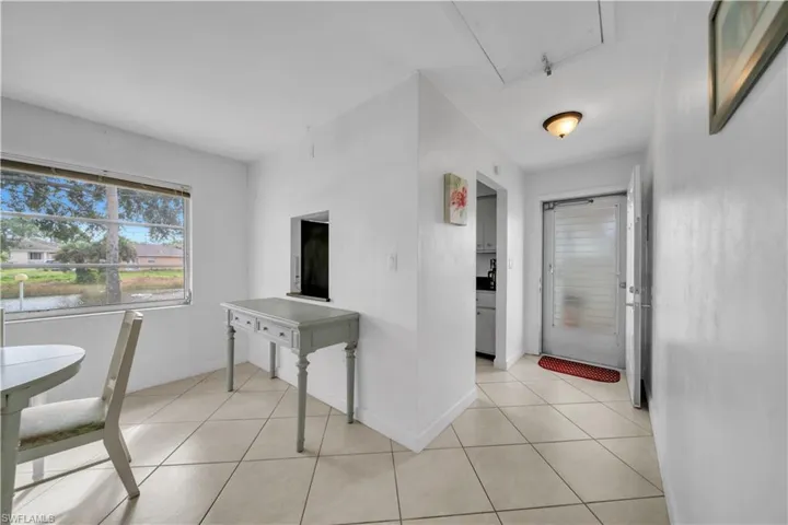 Hall featuring light tile patterned flooring and healthy amount of natural light