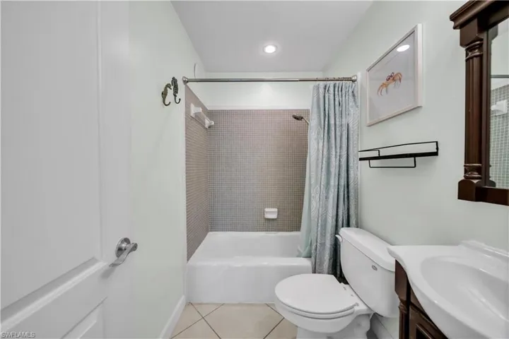 Bathroom with shower / bath combo, vanity, light tile patterned floors, and recessed lighting