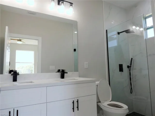 Dual vanity with white cabinetry, quartz countertop, and matte black fixtures