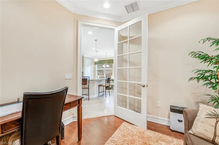 Office area with crown molding, french doors, and light hardwood / wood-style floors
