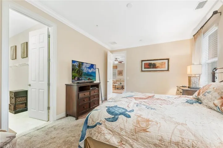Bedroom featuring light carpet and crown molding