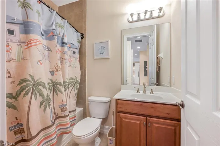 Full bathroom featuring shower / tub combo with curtain, toilet, and vanity