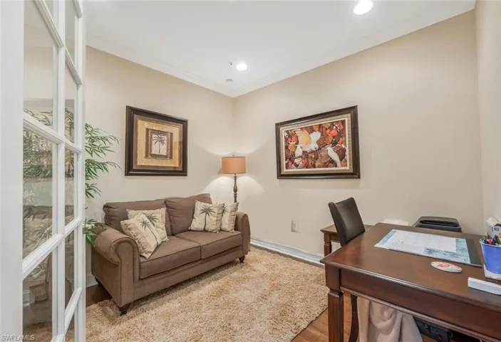 Office with light hardwood / wood-style floors and crown molding
