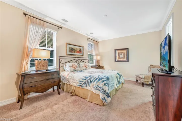 Carpeted bedroom with ornamental molding