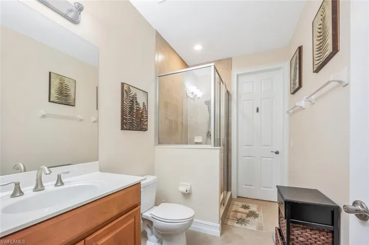 Bathroom with tile patterned flooring, vanity, walk in shower, and toilet