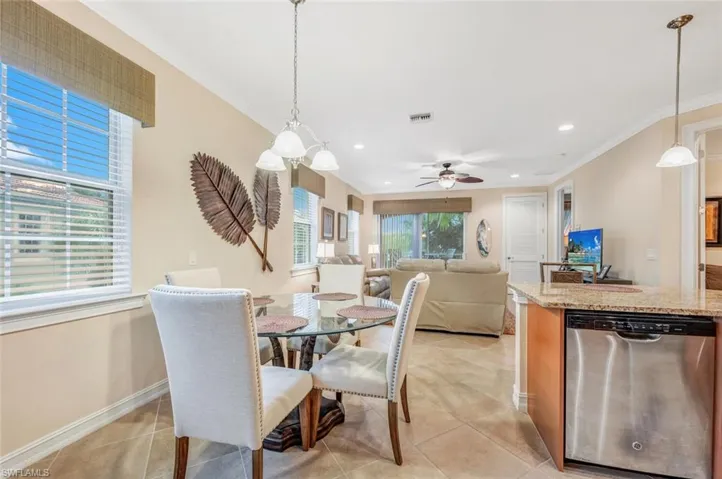 Dining area featuring ceiling fan, ornamental molding, and light tile patterned floors