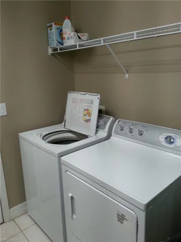 Washroom featuring separate washer and dryer and light tile floors