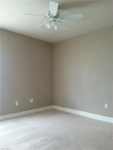Spare room featuring carpet floors and ceiling fan