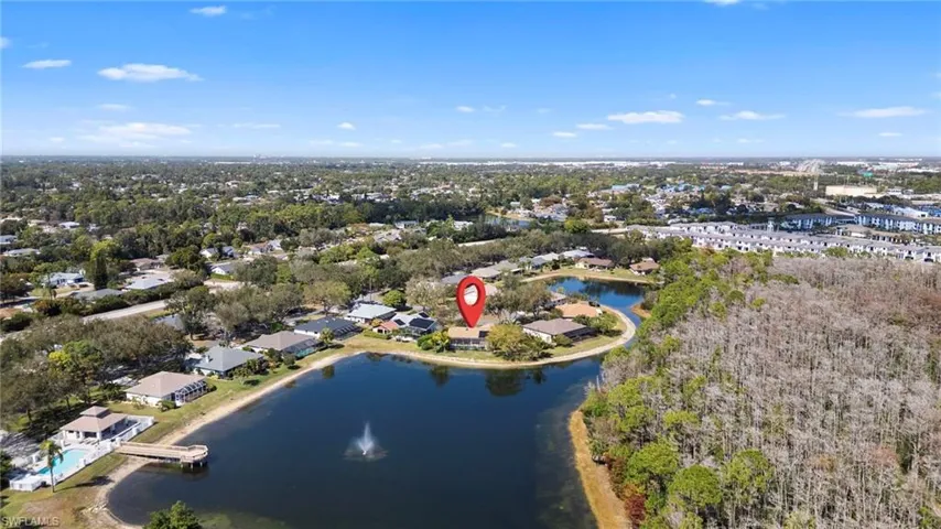 Aerial view of property and surrounding area with a large body of water and nearby suburban area