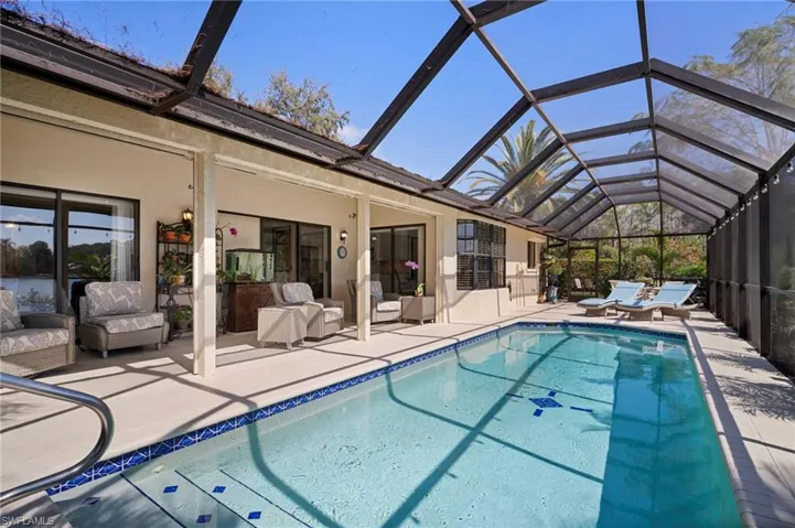 Outdoor pool with a sunroom, a patio, and a lanai