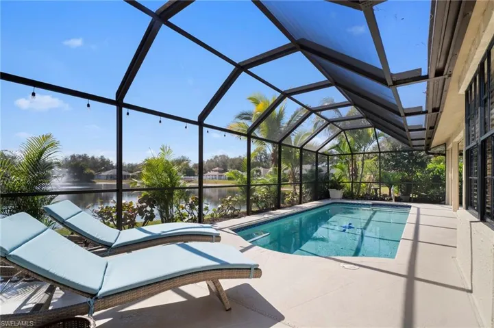 Outdoor pool with a sunroom, a lanai, a patio, and a water view