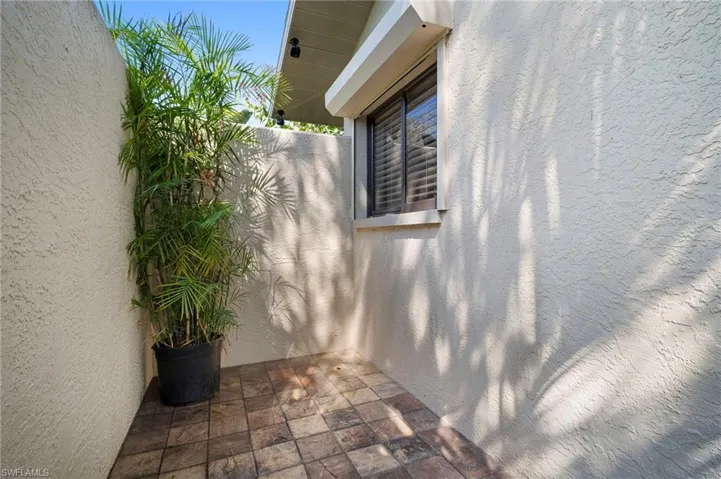 View of side of property with stucco siding and a patio