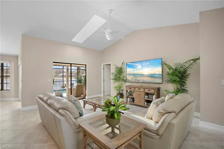 Living area featuring a skylight, a high ceiling, and a ceiling fan