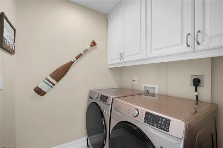 Laundry room with separate washer and dryer and cabinet space