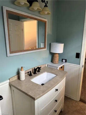 Bathroom with a wainscoted wall, vanity, and wooden walls