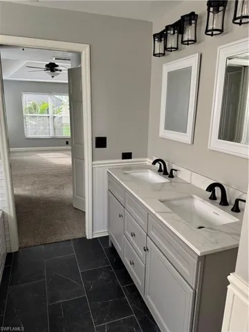 Bathroom featuring double vanity and a ceiling fan