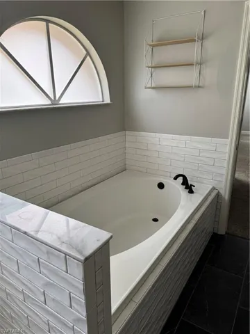 Full bath with a bath and tile patterned floors