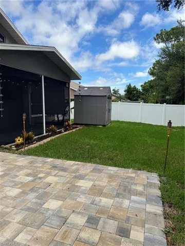 View of yard with a storage shed and a patio