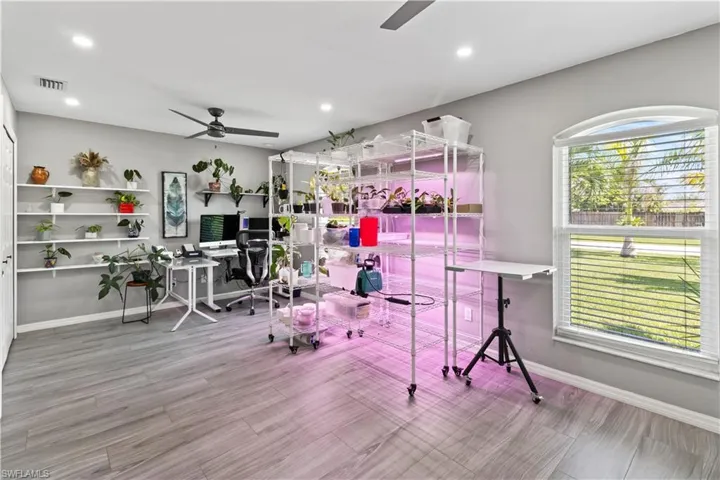 Living room with vaulted ceiling, light tile patterned floors, and ceiling fan