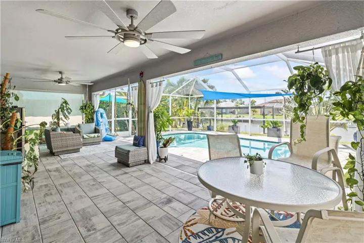 Outdoor pool featuring a ceiling fan, outdoor dining space, a patio, and a lanai