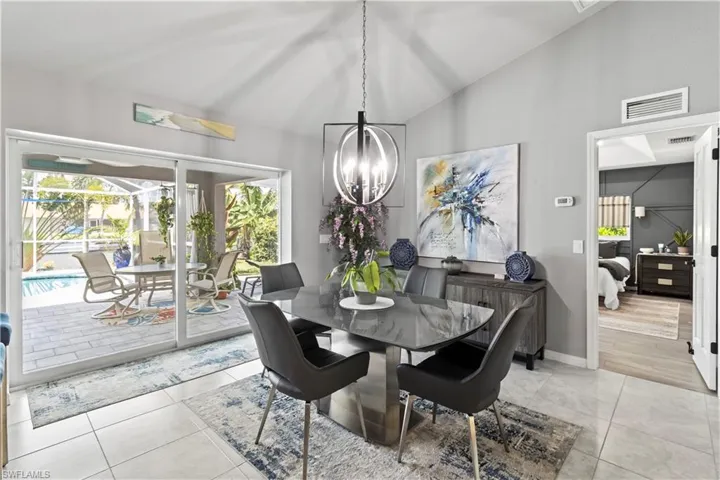 Dining area with light tile patterned floors and high vaulted ceiling