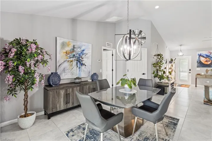 Dining room with vaulted ceiling, recessed lighting, a chandelier, light tile patterned floors, and a ceiling fan