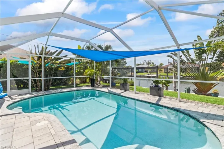 Swimming pool with a lanai, a patio, and a water view