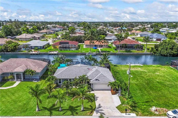 Aerial perspective of suburban area with a pool area and a nearby body of water