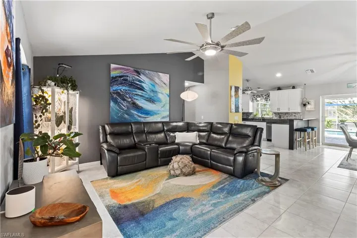 Living room featuring a ceiling fan, light tile patterned flooring, high vaulted ceiling, and recessed lighting