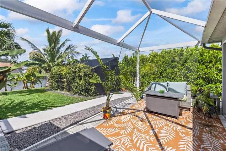 View of grassy yard with an outdoor pool and glass enclosure
