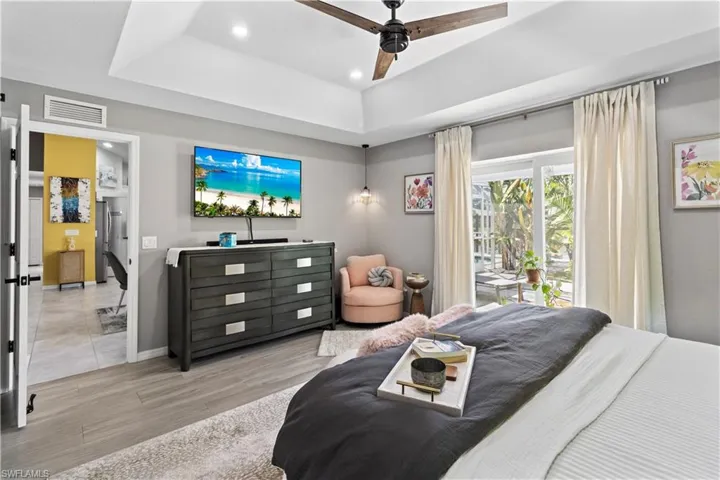 Living room featuring vaulted ceiling, a ceiling fan, and tile patterned flooring