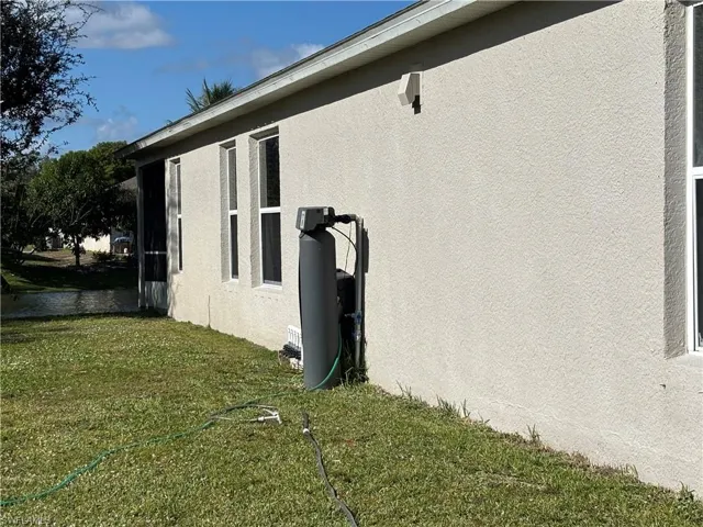 View of home's exterior featuring stucco siding and a yard