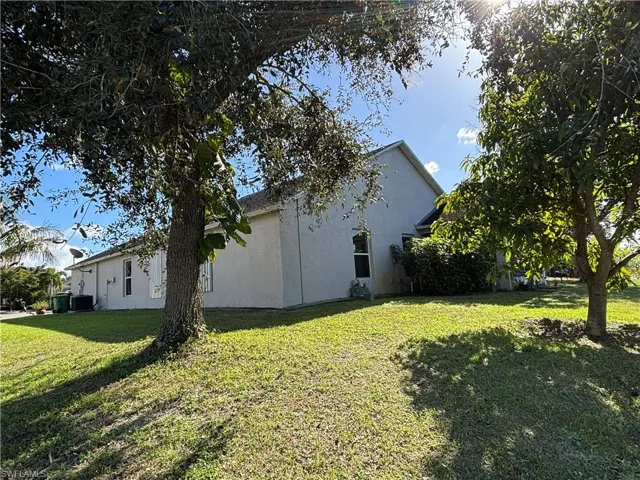 View of home's exterior featuring stucco siding and a lawn
