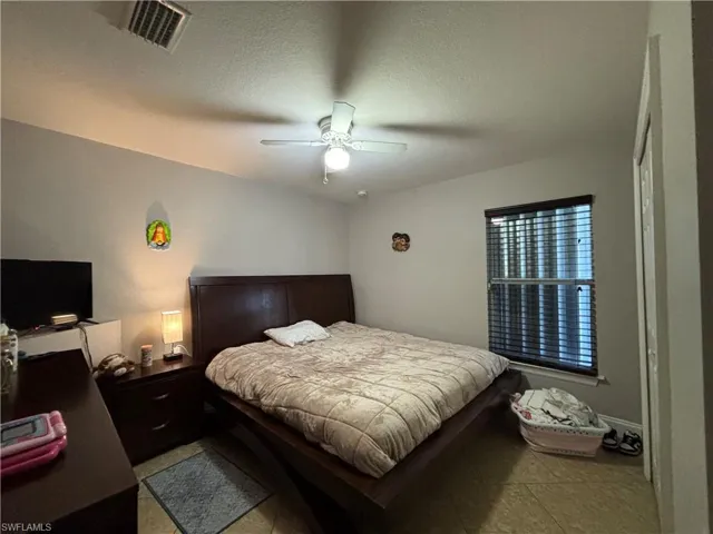 Bedroom with a textured ceiling and a ceiling fan