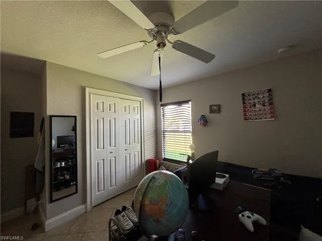 Office with tile patterned floors and a textured ceiling