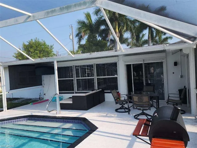 Rear view of property featuring glass enclosure and a patio area