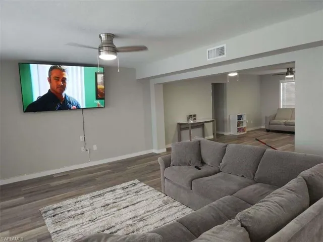 Living room featuring dark hardwood / wood-style flooring and ceiling fan