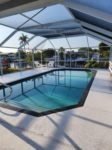 View of swimming pool featuring a lanai and a patio