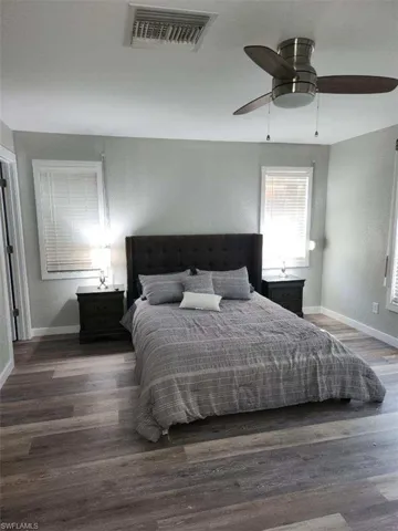 Bedroom with dark hardwood / wood-style flooring and ceiling fan