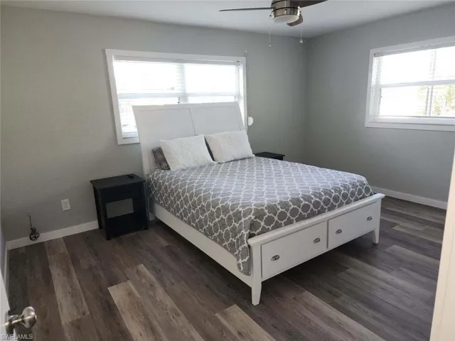 Bedroom with ceiling fan and dark wood-type flooring