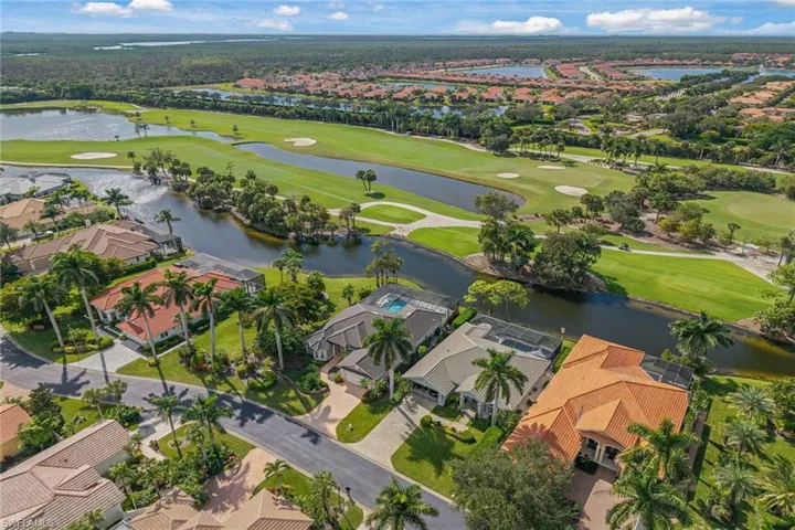 Aerial view of property and surrounding area featuring nearby suburban area and a golf club