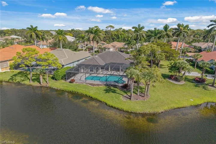 Aerial view of residential area featuring a pool and a nearby body of water