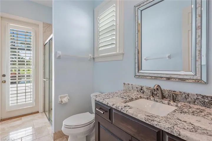 Bathroom featuring healthy amount of natural light, a stall shower, and vanity