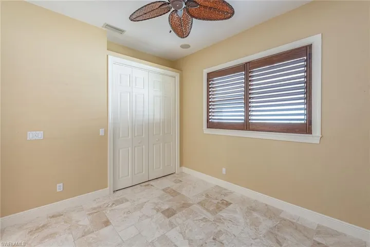 Unfurnished bedroom with a ceiling fan and a closet