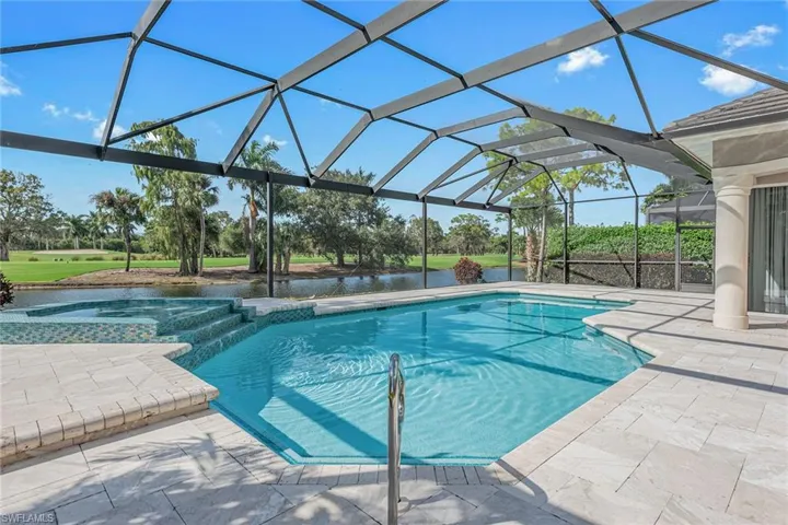 View of pool featuring a patio area, a sunroom, a pool with connected hot tub, a lanai, and a water view